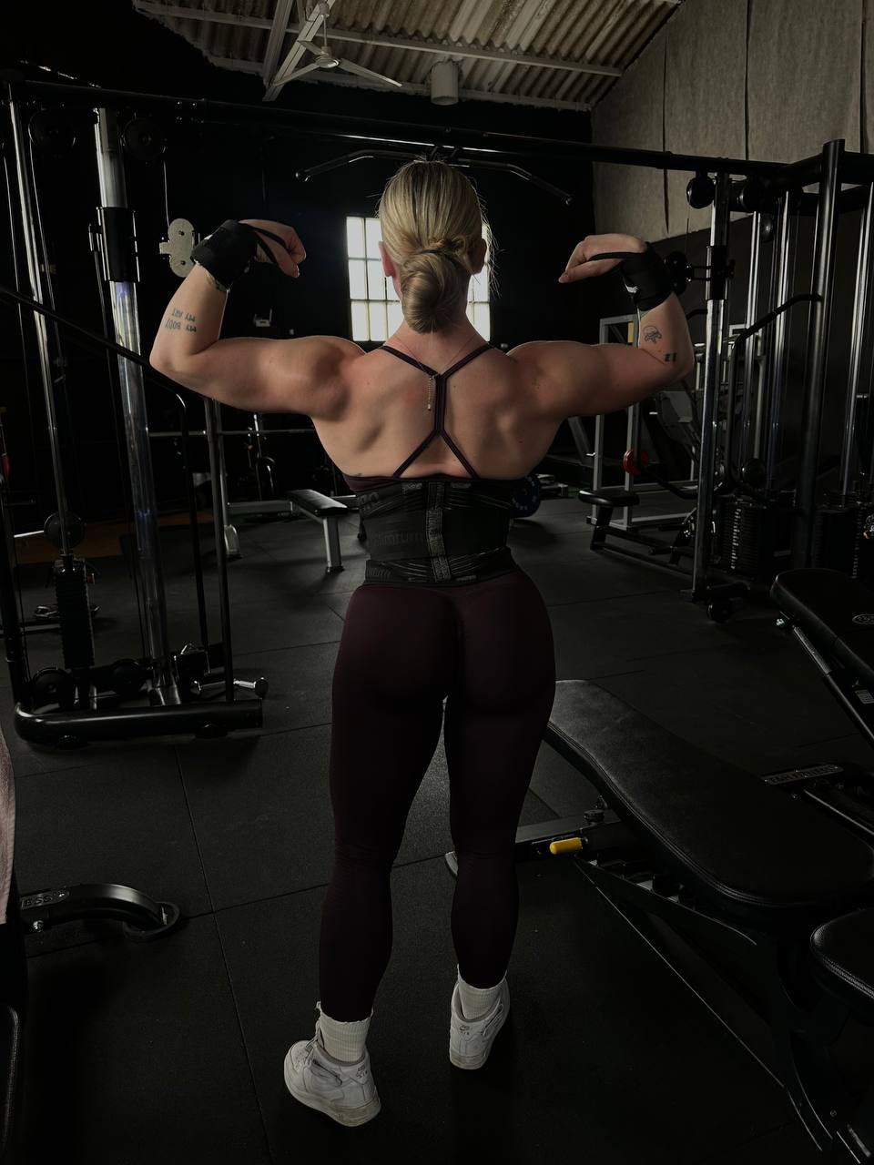 Judith Ramos marcando espalda y bíceps en la sala del gimnasio